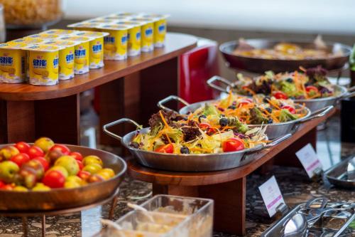 Un buffet de comida en sartenes de metal en exhibición en Arthur Hotel Baiyun Station Xinshixu Subway Station Guangzhou, en Guangzhou
