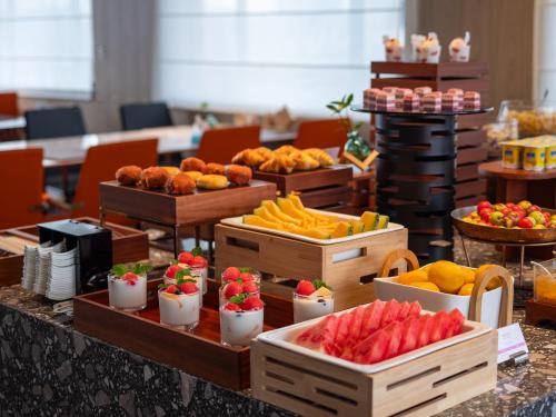 Un buffet con muchas cajas de comida en una mesa. en Arthur Hotel Baiyun Station Xinshixu Subway Station Guangzhou, en Guangzhou