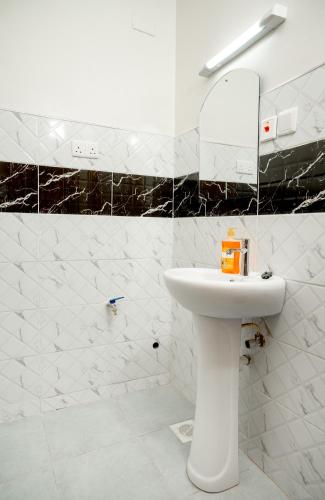 a white bathroom with a sink and a mirror at Amno Elite Suites in Naivasha
