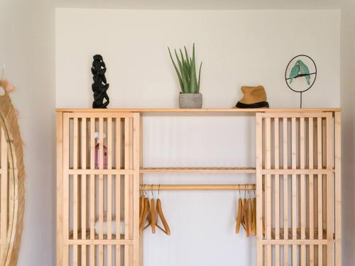 a wooden shelf with hats and a plant on top at Blue Horizon Retreat in Playa del Aguila