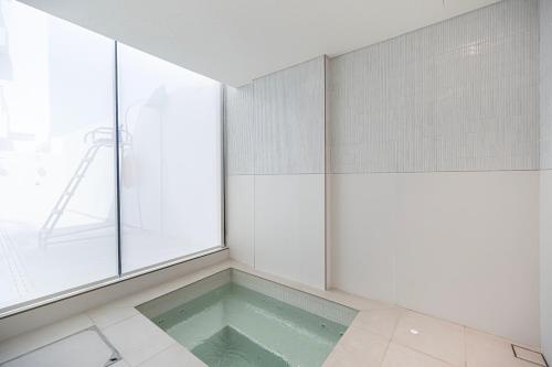 a room with a pool of water next to a window at Elegant 2BR With Modern Design Near to Circle Mall in Dubai