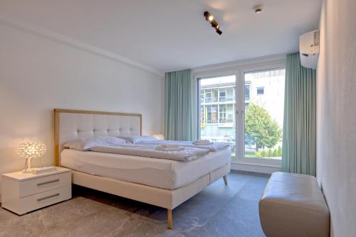 una camera da letto con un letto e una grande finestra di Apartment JungfrauCenter Brienzersee - GRIWA RENT a Interlaken