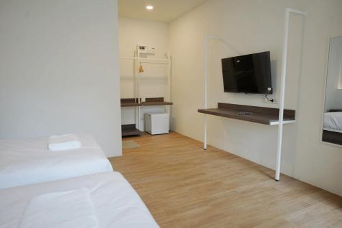 a room with a bed and a tv on a wall at Matini Hotel BU