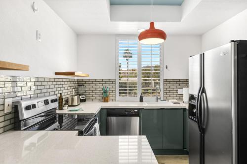 パーム・スプリングスにあるEl Cielo 20のキッチン(ステンレス製の冷蔵庫付)、窓が備わります。