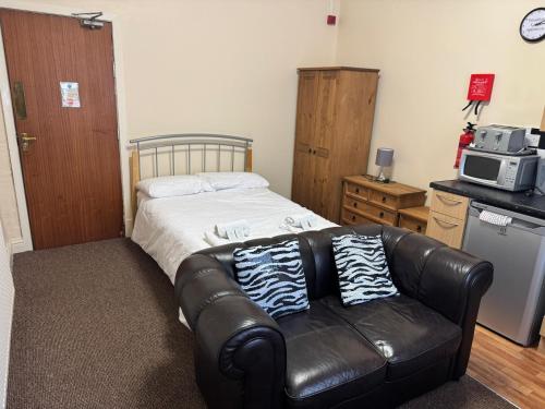een slaapkamer met een leren bank en een magnetron bij Woodfield Lodge Apartments in Blackpool