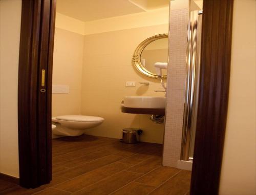 a bathroom with a toilet and a sink and a mirror at Hotel Villa Clementina in Scafati