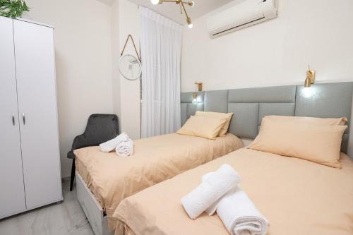 a bedroom with two beds and a chair at Moses Luxury apartment 38 jerusalem in Safed