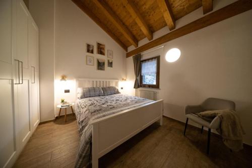 a bedroom with a bed and a chair and a window at Casa Closellinaz in Roisan