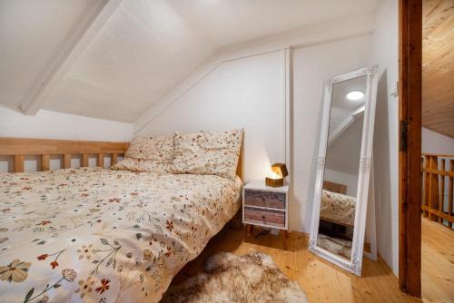 a bedroom with a bed and a mirror at LES-wellness in Pastviny