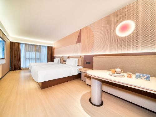 a hotel room with a bed and a table at Orange Hotel Hangzhou Songcheng in Hangzhou