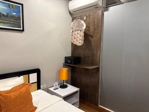 a bedroom with a bed with a lamp on a night stand at Ostro Hotel in Phnom Penh