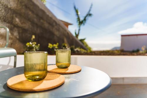 two glasses sitting on top of a table at GuestReady - Hillside Escape I in Câmara de Lobos