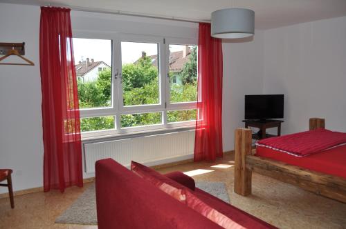 a living room with a large window with red curtains at Punkrock Harbour Pension Bähr in Karlsruhe