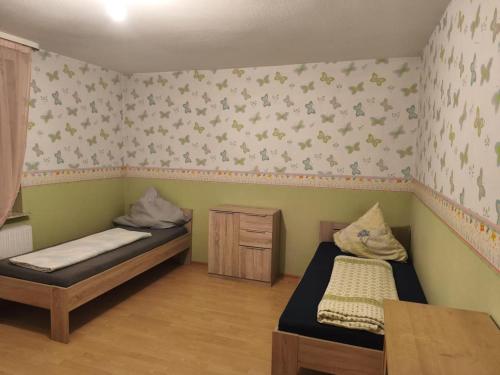 a room with two beds and a table in it at NEU! Monteurswohnung ASX Trubenhausen Gruppenunterkunft in Trubenhausen
