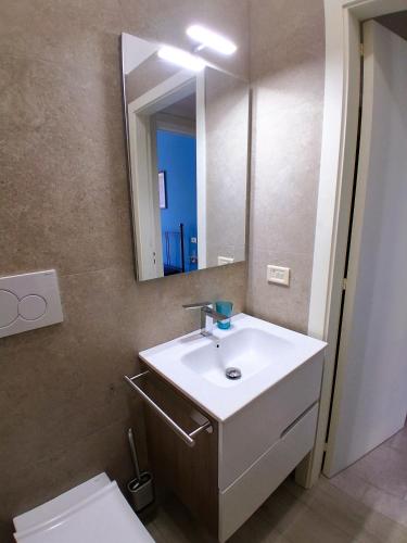 a bathroom with a sink and a mirror and a toilet at Via Pisa 20 in Bari