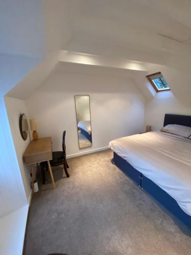 Un dormitorio con una cama, un escritorio y un espejo. en Brylach Steading, en Aberlour
