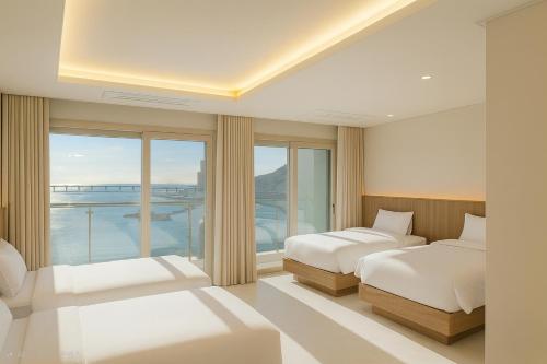 a bedroom with two beds and a large window at Magnum Nampo Hotel in Busan