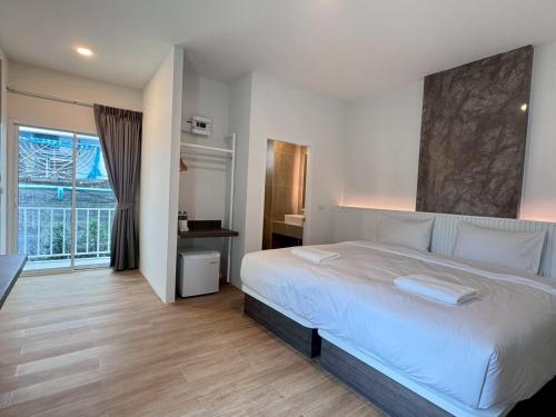 a bedroom with a white bed and a large window at Matini Hotel BU 