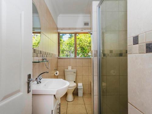 a bathroom with a sink and a toilet and a shower at St. Lucia Safari Lodge in St Lucia