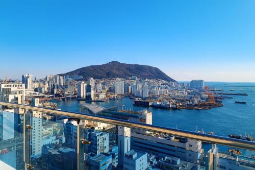 Magnum Nampo Hotel في Jung-gu: اطلالة على مدينة جبلية في الخلفية