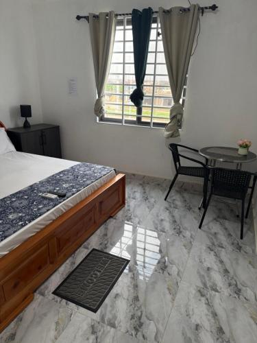 una camera da letto con un letto, un tavolo e una finestra di Kings Lounge a Ayaso