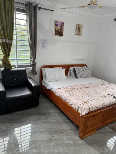 una camera da letto con un letto e una sedia nera di Kings Lounge a Ayaso