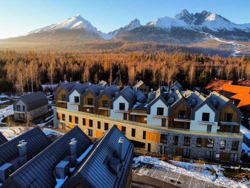 una vista aérea de una ciudad con montañas cubiertas de nieve en TATRYSTAY Brezy Luxury Apartment, en Stará Lesná