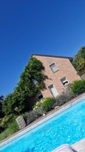 een gebouw met een zwembad ervoor bij Chez Isa in Malmedy