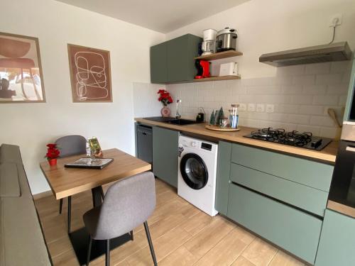 une cuisine avec une table et une machine à laver dans l'établissement Longanea 1, à Saint-Pierre