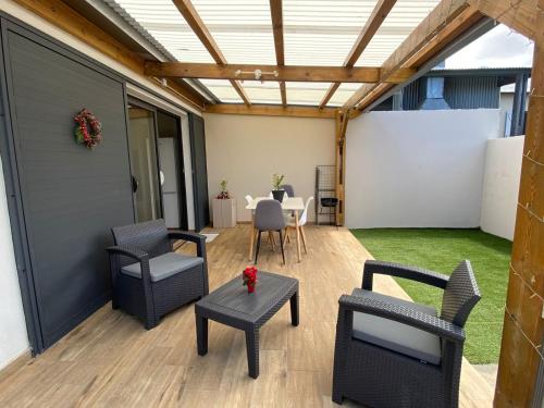 une terrasse couverte avec des chaises et une table et une table dressée dans l'établissement Longanea 1, à Saint-Pierre