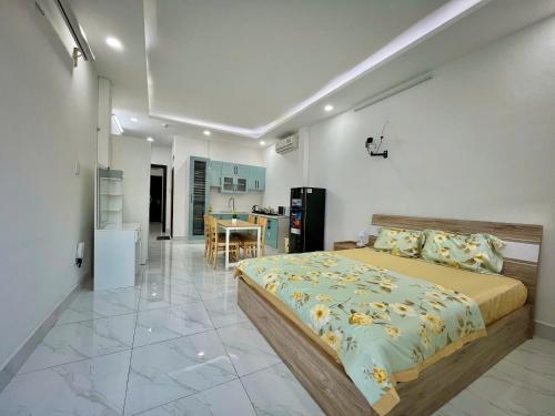 a bedroom with a large bed and a kitchen at AP Home in Ho Chi Minh City