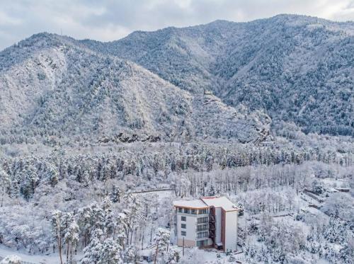 um edifício no meio de uma montanha de neve em Emerald Borjomi Hotel em Borjomi