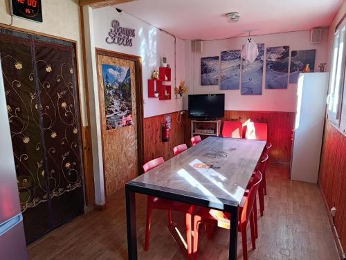 a dining room with a table and red chairs at Gîte Espace et Montagne in Aragnouet