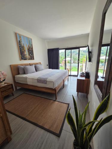 a bedroom with a bed and a large window at DHM Hotel in Kuta Lombok