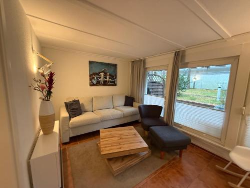 a living room with a couch and a table at Inselglück unter Reet 100m zum Strand - Garten & Privatterrasse - Hund willkommen in Karlshagen