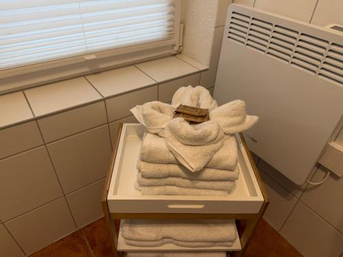a pile of towels on a shelf in a bathroom at Inselglück unter Reet 100m zum Strand - Garten & Privatterrasse - Hund willkommen in Karlshagen
