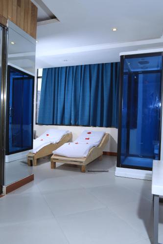 two beds in a room with a window at My Dream Apartments - 4 miles from Bole International Airport in Addis Ababa