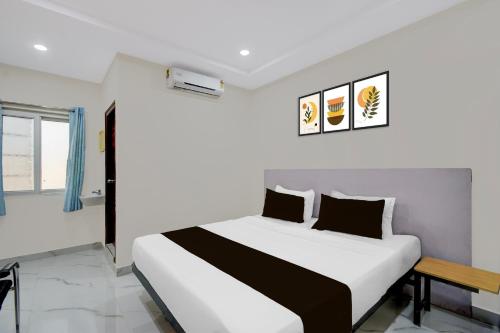 a white bedroom with a bed and a table at Super Townhouse Oak Bachupally Medical College Formerly SV Hotels in Lingampalli