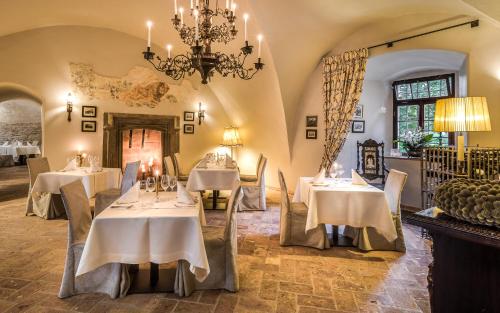 una sala da pranzo con tavoli bianchi e lampadario pendente di Zamek Karpniki Schloss Fischbach a Łomnica