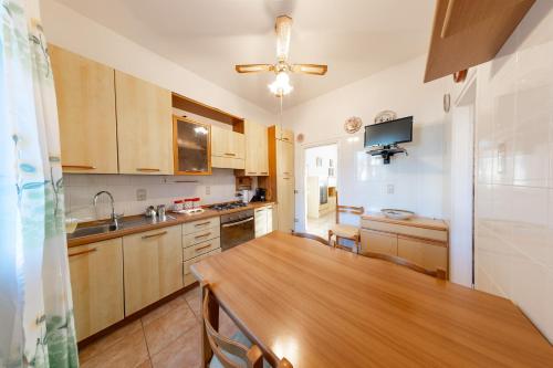 una cucina con mobili in legno e un tavolo in legno di Lido Adriano Garden House a Lido Adriano