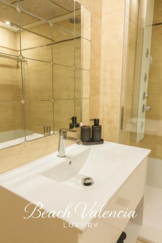 a bathroom with a white sink and a mirror at BEACH VALENCIA LUXURY A40-13 Apartment with terrace and sea views in Valencia