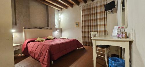a bedroom with a bed and a table in a room at Agriturismo Cà Del Lupo in Palazzolo sullʼOglio