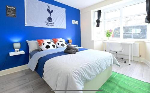 a blue bedroom with a bed with a stuffed animal on it at Fina's House - Moments from Tottenham Hotspur Stadium in London