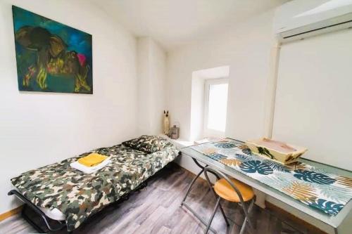 Zimmer mit einem Bett und einem Schreibtisch. in der Unterkunft L'Occitane Maison de village climatisée in Lapalme