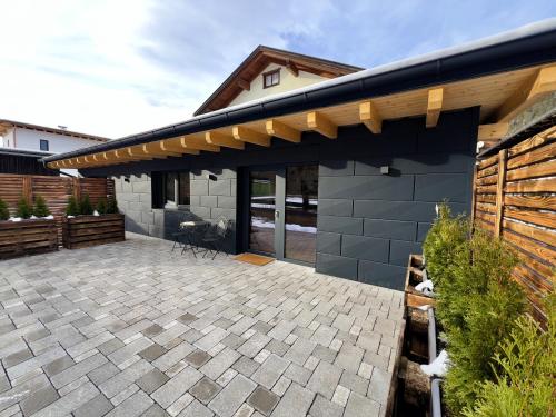 a patio of a house with a roof at LechHuamat in Weissenbach am Lech