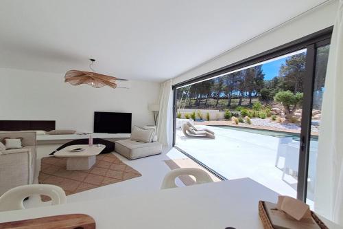 een woonkamer met een grote glazen schuifdeur bij Casa Bianca - Villa d'architecte avec piscine in Leucate