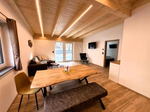 a living room with a wooden table and a couch at LechHuamat in Weissenbach am Lech
