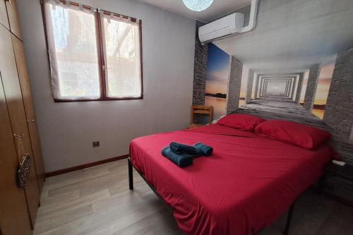 a bedroom with a red bed with a red blanket at L'évasion des Corbières in Portel-des-Corbières