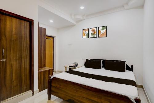 Un dormitorio con una cama y una puerta de madera. en Hotel O Oragadam Industrial Estates Chennai Formerly SSM Rooms, en Chennai