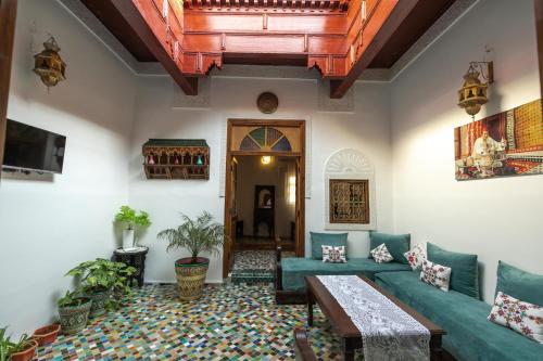 een woonkamer met een bank en een tafel bij Dar El Kendil in Fès